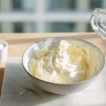 Cremige Buttercreme ohne Pudding wird in moderner Küche aufgeschlagen
