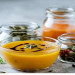 Vegane Kürbissuppe Zutaten in modernen Glasbehältern auf der Küchenarbeitsplatte