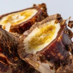 Frisch geerntete Changbai‑Bergwurzel mit Erde auf Holzuntergrund