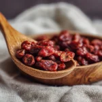 Getrocknete Berberitzen in einem Holzlöffel auf Leinentuch