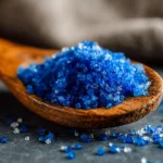 Nahaufnahme von blauen Salz-Kristallen auf dunklem Untergrund