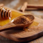 Honig mit Zimt in Holzlöffel auf Brett