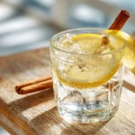 Apfelessig Soda Drink mit Zitrone und Zimt auf Holztisch